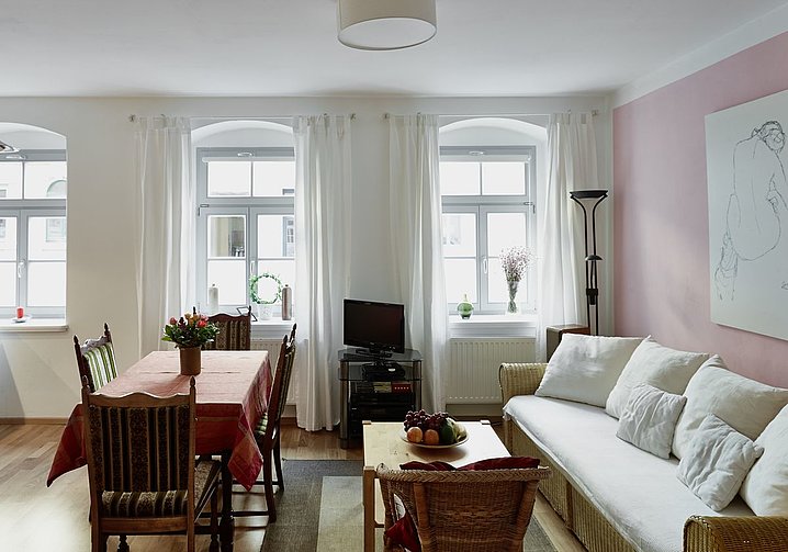 Ansichten der familienfreundlichen Ferienwohnung PRIESSNITZ Dresden, hier das Wohnzimmer mit Blick auf Sofa, Essplatz und TV